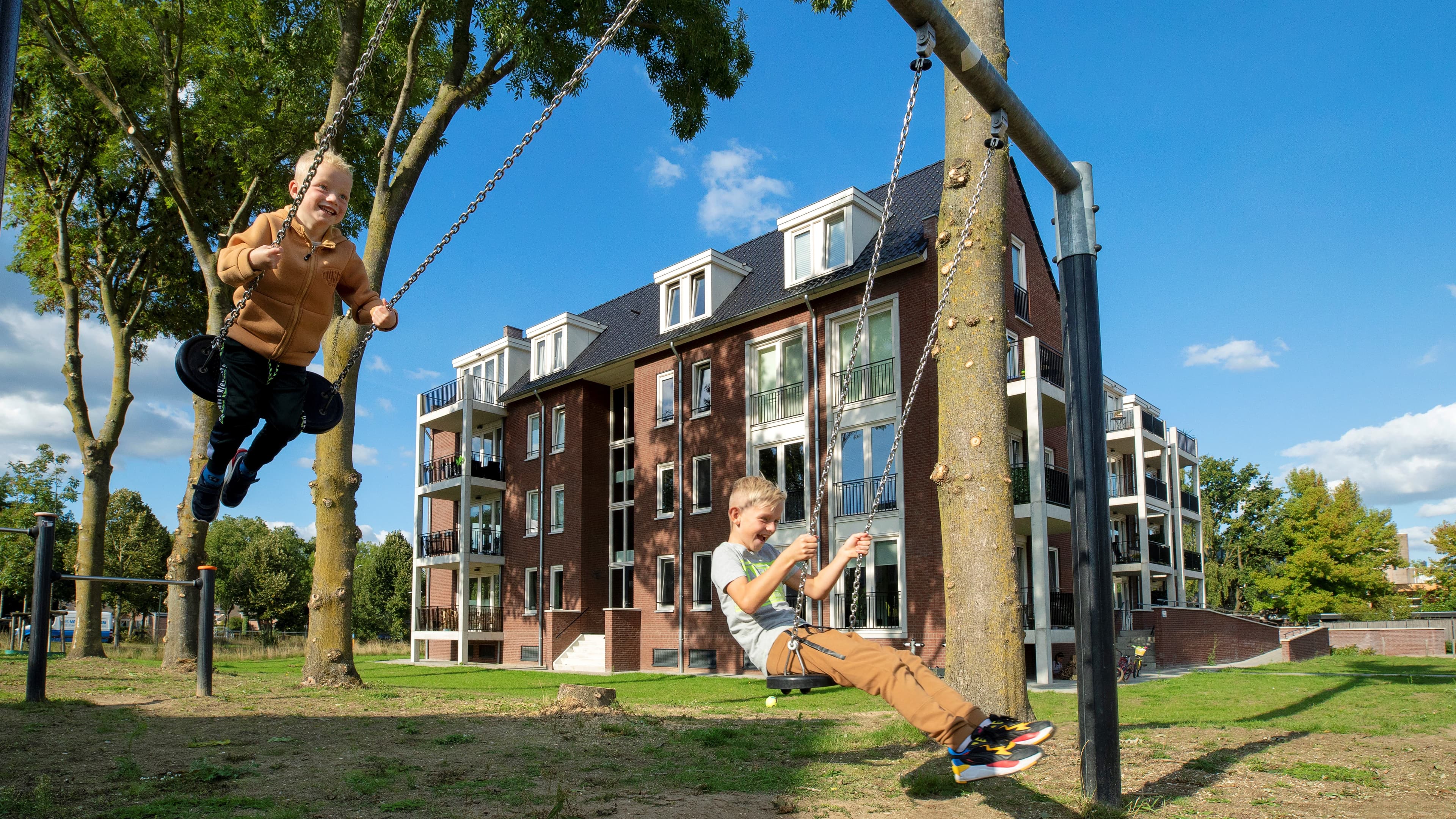 kinderen op schommel in nieuwbouw wijk