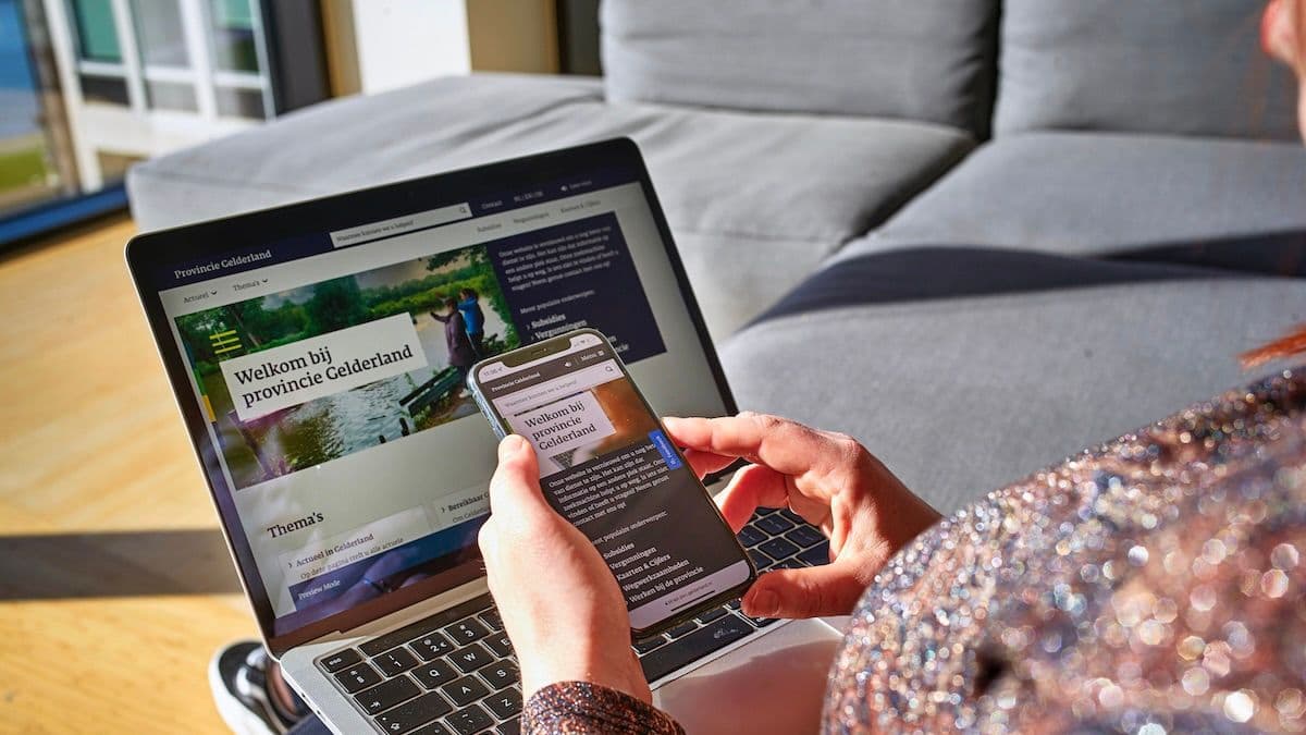 laptop op schoot en smartphone in hand